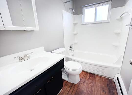 A white sink with a black cabinet below it.