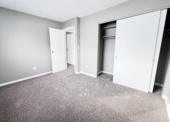 A room with grey carpet and white walls.