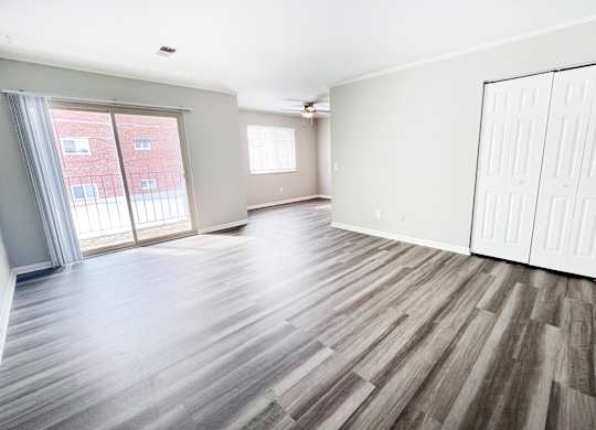 A room with wooden flooring and white walls.