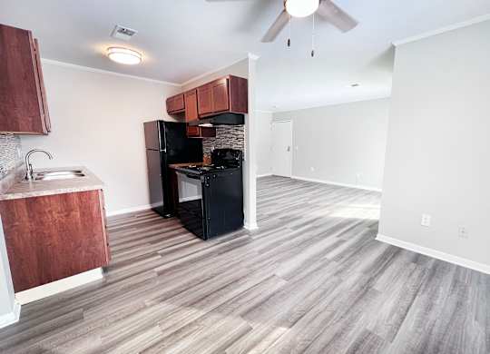A kitchen with a black fridge and stove top oven.