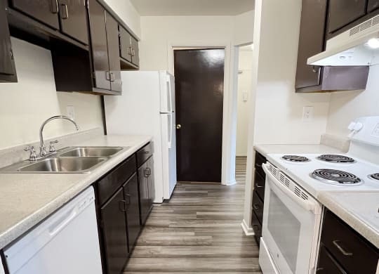 an empty kitchen with white appliances and black and white cabinets at Four Worlds Apartments, Ohio, 45231