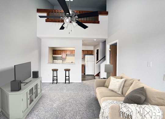 A living room with a television, a couch, and a ceiling fan.