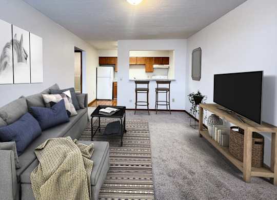 A living room with a grey couch and a television on a wooden stand.