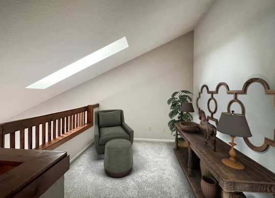 A living room with a grey armchair and a wooden table with a lamp on it.