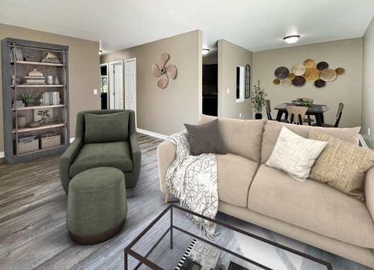 A living room with a green chair, a brown couch, and a wooden bookcase.