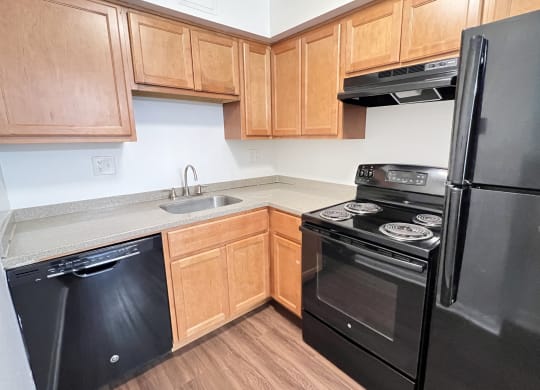 a kitchen with black appliances and wooden cabinets at Walnut Creek Townhomes, Cincinnati, 45236