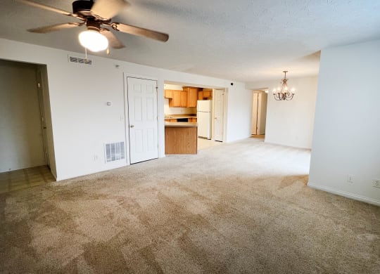 an empty living room with a ceiling fan and a kitchen  at Walton Ridge Apartments, Walton, Kentucky
