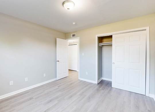 an empty living room with white doors and a door to a closet