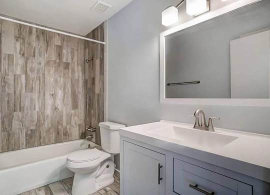 A white toilet sits next to a white sink in a bathroom.