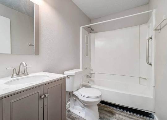 A white toilet sits next to a sink in a bathroom.