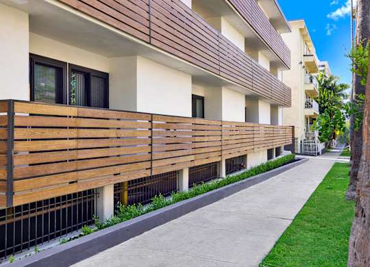 A modern building with a wooden balcony railing.