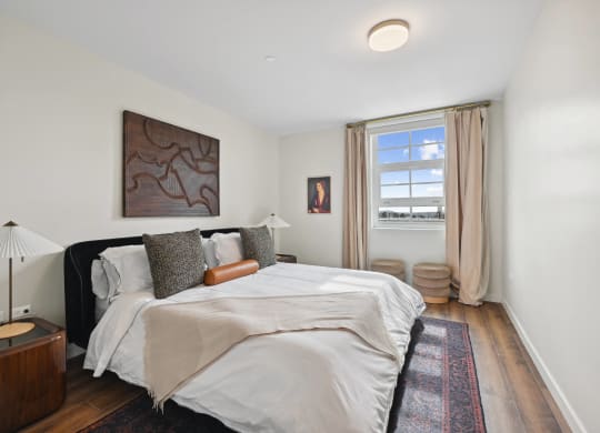 bedroom with white walls and a large bed and a window The Baxter in Los Angeles, CA 90028