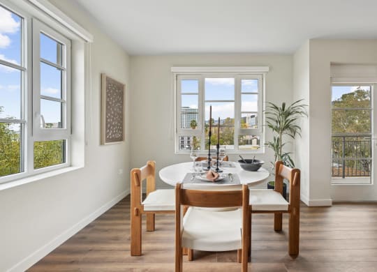 a dining room with a table and chairs and windows The Baxter in Los Angeles, CA 90028