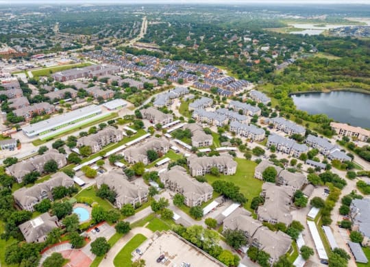 an aerial view of a neighborhood with houses and a lake at The Clairborne Apartment Homes, Grand Prairie, TX, 75050
