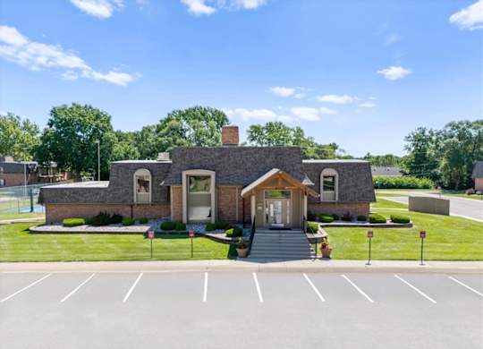 A small building with a parking lot in front.