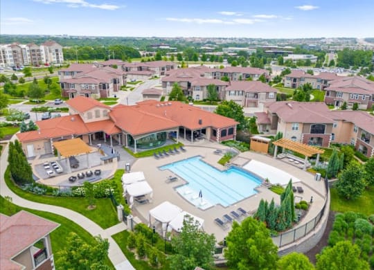 an aerial view of a swimming pool in a neighborhood with houses