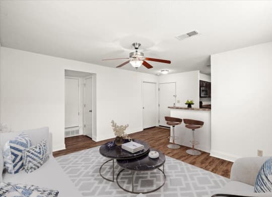 an open living room and kitchen with a ceiling fan at Fiesta Square Apartments & Townhomes, Overland Park