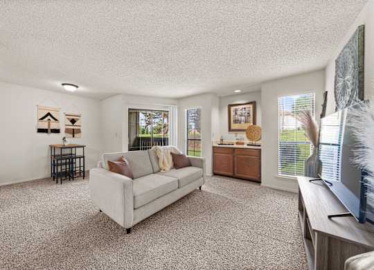 A living room with a couch, a television, and a window.