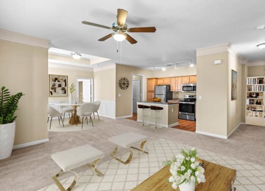 A living room with a ceiling fan, crown molding and open layout at Avignon Apartments in Olathe, Kansas