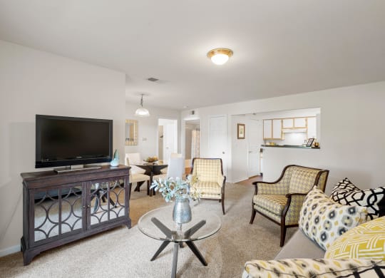 a living room with couches and chairs and a flat screen tv at Stonebriar Woods, Overland Park