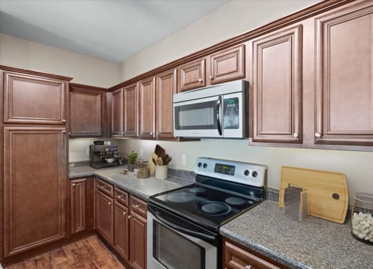 A modern gourmet kitchen with stainless steel appliances, dark espresso cabinetry, lots of counter space, and lots of storage space.