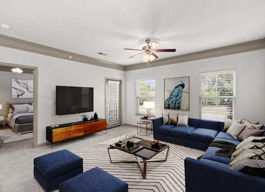 a living room with a couch coffee table and a tv on the wall at Stonepost Crossing Apartments, Overland Park, Kansas