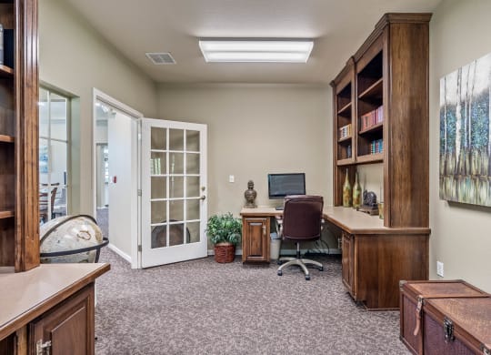an office with a computer and a bookshelf