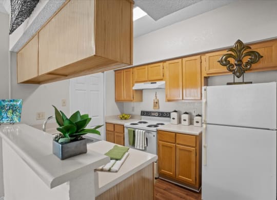 a kitchen with a white refrigerator freezer next to a stove top oven at Creekview Apartment Homes, Texas, 75254