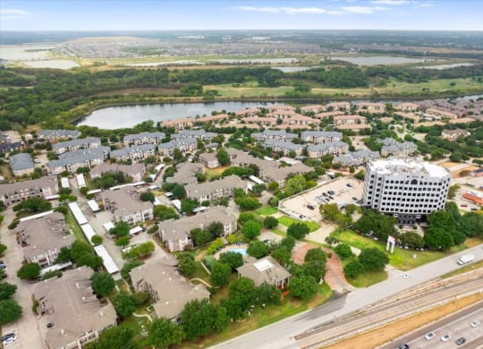 an aerial view of a city with a lake in the background at The Clairborne Apartment Homes, Grand Prairie, TX