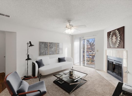a living room with a white couch and a fireplace at Deerfield Apartments, Kansas