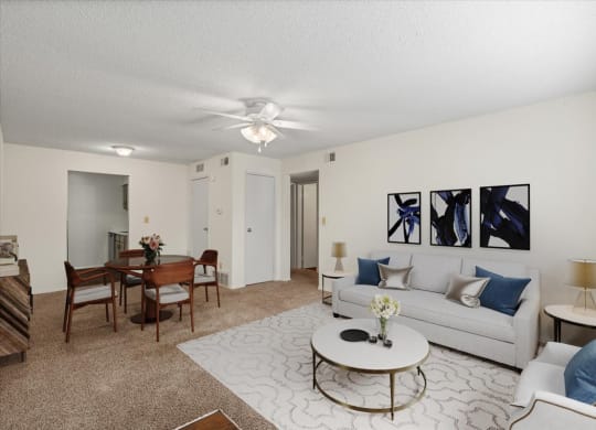 A living room with a dining space, a ceiling fan, and a hallway closet.