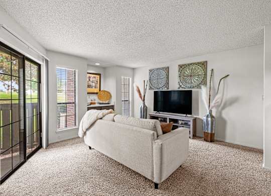 A living room with a white couch and a television.