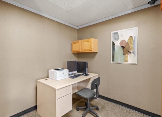 a desk with a computer and a printer in a room
