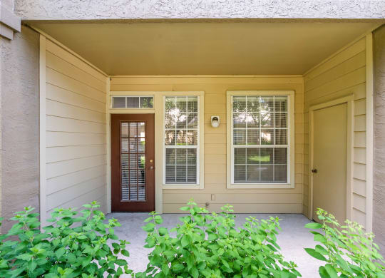 a front porch with a door and windows