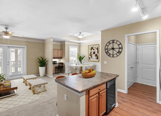 An open kitchen with hardwood floors, a kitchen prep island, and a wine fridge