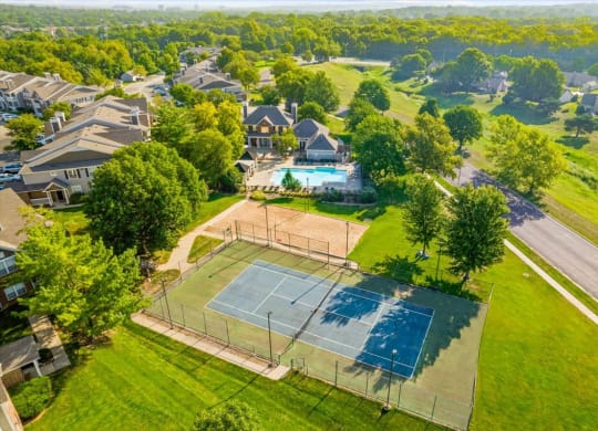 an aerial view of a house with a tennis court in the foreground and a swimming pool inat Stonebriar Woods Apartments, Kansas, 66213