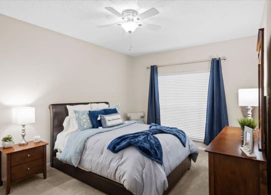 a bedroom with a bed and two night stands at Creekview Apartment Homes, Texas