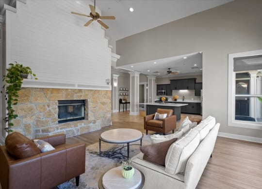 A living room with a stone fireplace and a brown leather couch.