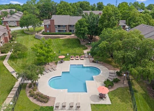 an aerial view of a swimming pool in the backyard of a house at Highland Park Apartment Homes, Overland Park