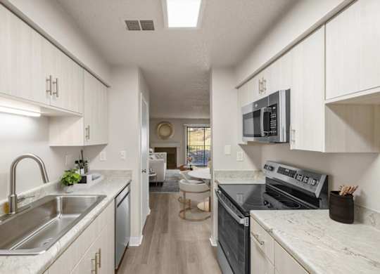 A kitchen with white cabinets and a black stove top oven.