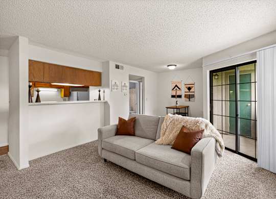 A living room with a grey couch and a wooden cabinet.
