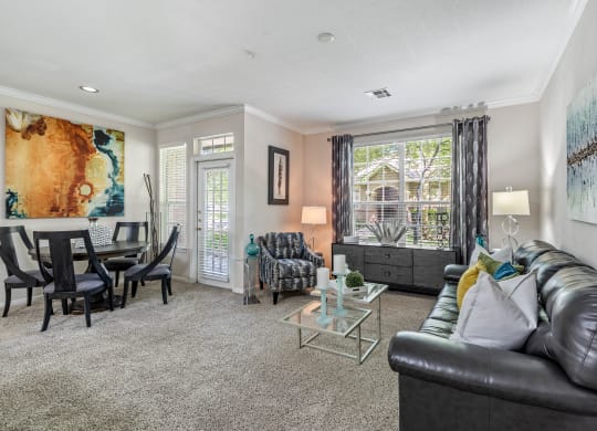 a living room with a couch and a chair in front of a table with a chair and