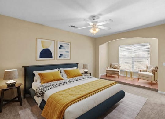 A large bedroom with a ceiling fan and library niche at Avignon Apartments in Olathe, Kansas