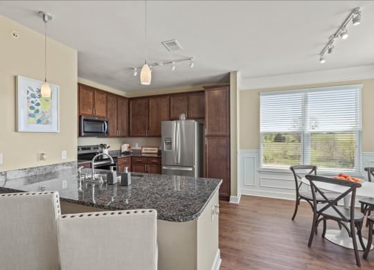 a kitchen with a granite counter top and a table with chairs at The Residences at Bluhawk, Overland Park, 66085