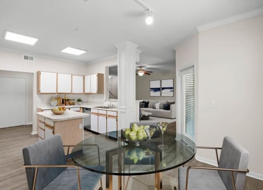 A dining area with track lighting, patio access next to an open kitchen.
