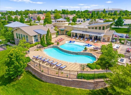 an aerial view of a resort style pool with lounge chairs