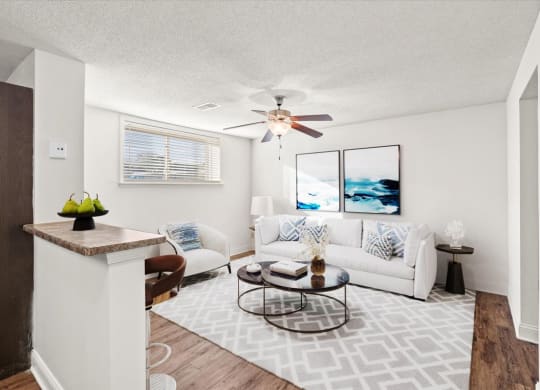 a living room with a couch and a ceiling fan at Fiesta Square Apartments & Townhomes, Kansas