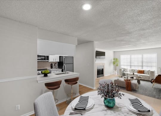 a kitchen and living room with a table and chairs at Highland Park Apartment Homes, Overland Park