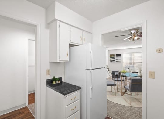 a kitchen with white cabinets and a white refrigerator