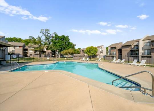 Swimming pool surrounded by lounge chairs at Bremerton Park Apartment Homes , Prairie Village, Kansas